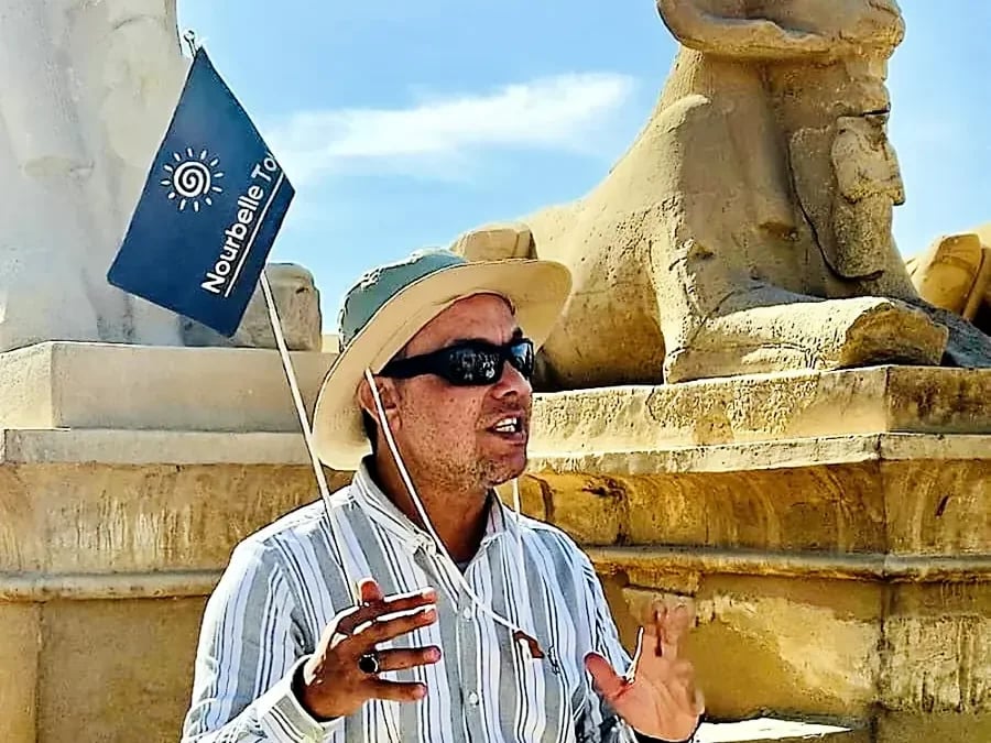 Nourbelle guide with the Nourbelle Tours flag at Karnak Temples